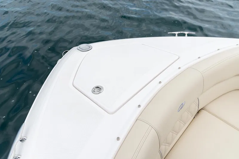 Slide: The Image of 2022 Regal 2800 Bowrider boat interior with white seating, docked on calm water. - 11