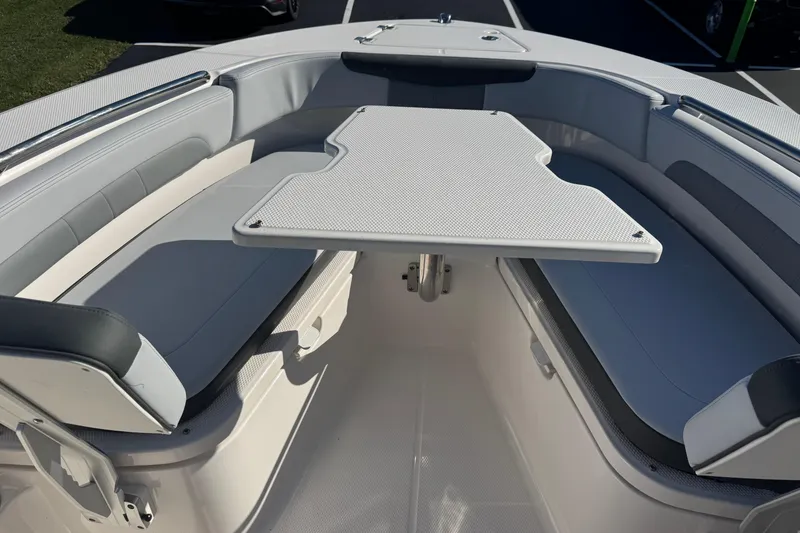 Slide: The Image of 2026 Robalo R202 Explorer boat interior with cushioned seating and a central table. - 11