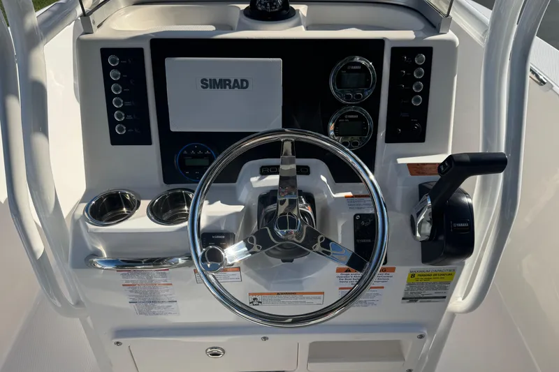 Slide: The Image of 2026 Robalo R202 Explorer boat dashboard with steering wheel and Simrad display. - 12