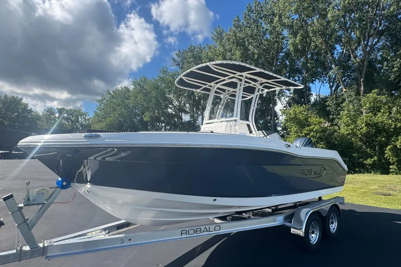 Slide: The Image of 2026 Robalo R202 Explorer boat on trailer, parked outdoors under cloudy sky. - 7