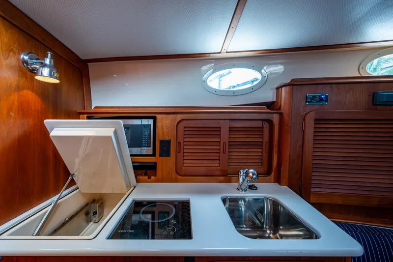 Slide: The Image of 2017 Hinckley Picnic Boat 37 MKIII interior kitchen with sink, stove, and microwave. - 20
