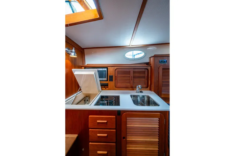 Slide: The Image of Interior of 2017 Hinckley Picnic Boat 37 MKIII galley with wood cabinetry and modern appliances. - 21