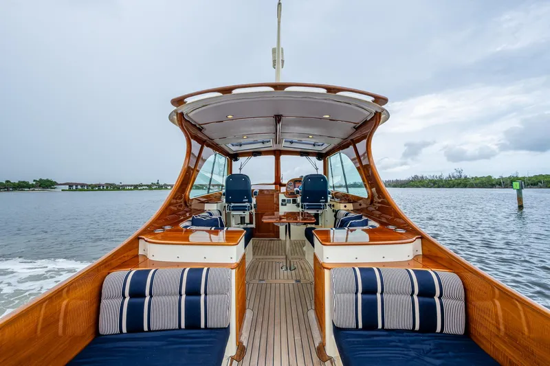 Slide: The Image of 2017 Hinckley Picnic Boat 37 MKIII on water, elegant interior, wooden finish, striped cushions. - 8