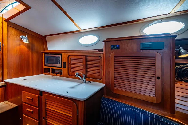 Slide: The Image of 2017 Hinckley Picnic Boat 37 MKIII interior with wooden cabinetry and modern amenities. - 17