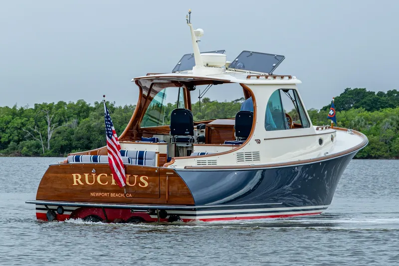 Slide: The Image of 2017 Hinckley Picnic Boat 37 MKIII cruising on water, rear view with American flag. - 4