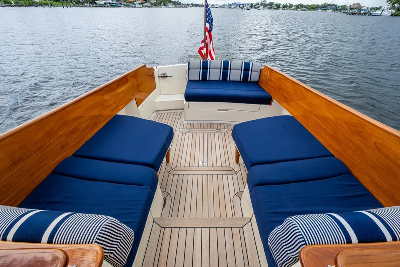 Slide: The Image of 2017 Hinckley Picnic Boat 37 MKIII with blue seating and wooden deck on the water. - 6