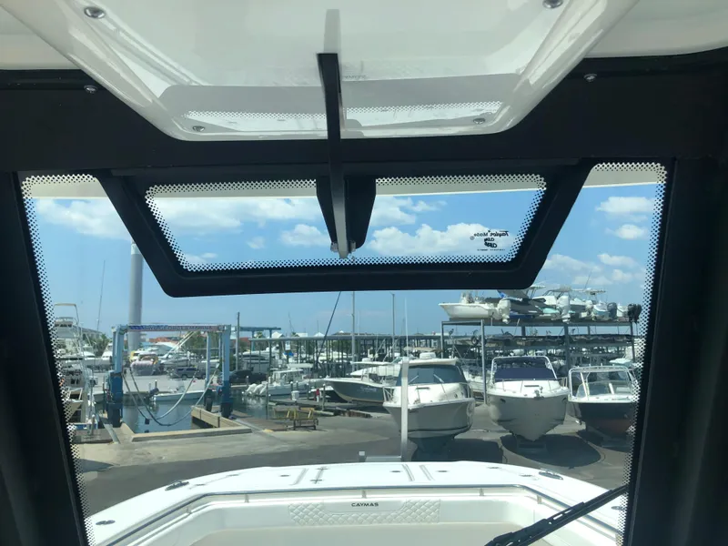 Slide: The Image of View from 2025 Caymas 30 CT boat cockpit overlooking marina with multiple boats docked. - 18