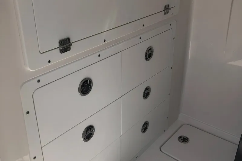 Slide: The Image of 2025 Caymas 30 CT boat storage compartments with secure latches. - 36