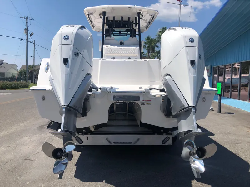 Slide: The Image of 2025 Caymas 30 CT boat with dual outboard engines, rear view. - 4