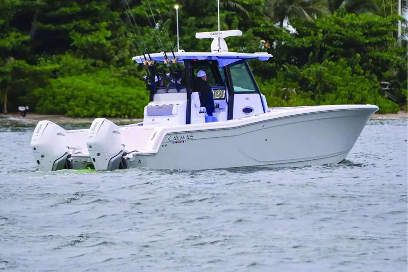 Slide: The Image of 2026 Caymas 30 CT boat cruising on water with twin Mercury engines. - 43