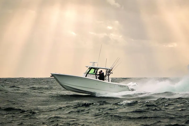 Slide: The Image of 2026 Caymas 30 CT boat navigating rough seas under dramatic sky. - 44