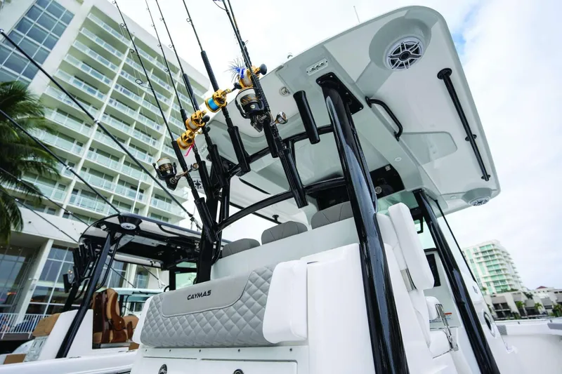 Slide: The Image of 2026 Caymas 30 CT boat with fishing rods, docked near modern buildings. - 45