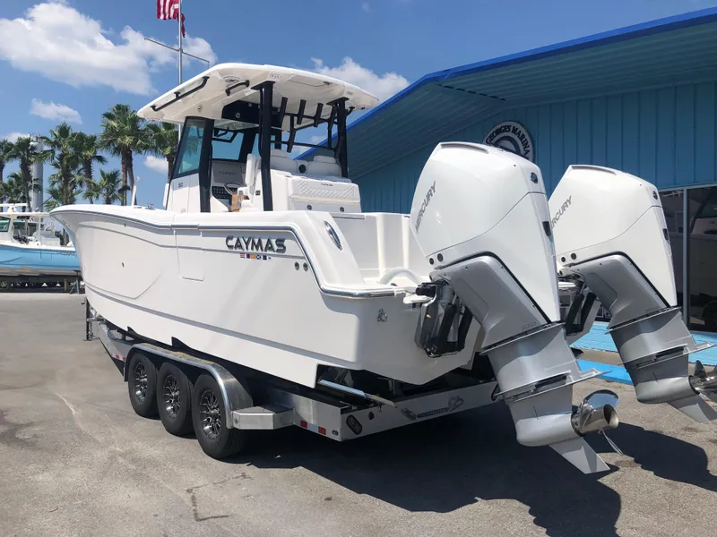 Slide: The Image of 2025 Caymas 30 CT boat with dual engines on trailer, parked outdoors. - 5