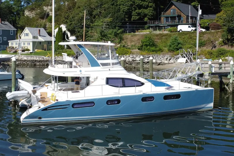 Slide: The Image of 2012 Leopard 47 PC Owners' Version catamaran docked in a scenic marina setting. - 0