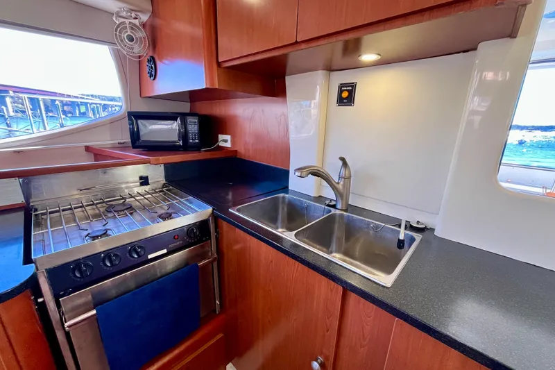 Slide: The Image of Galley kitchen in 2012 Leopard 47 PC Owners' Version yacht with stove, sink, and microwave. - 13