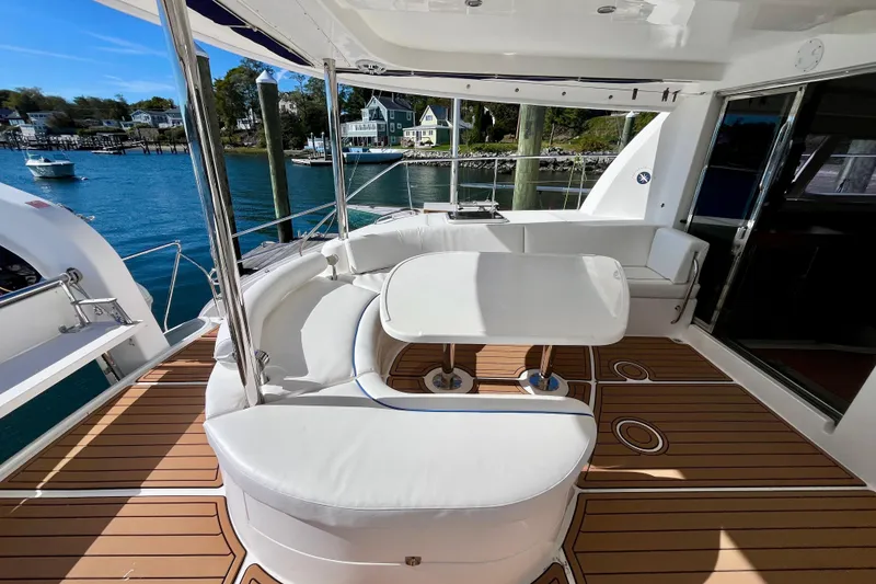 Slide: The Image of Luxurious 2012 Leopard 47 PC yacht deck with white seating and scenic waterfront view. - 14
