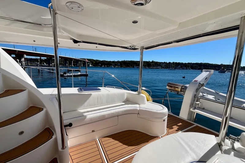 Slide: The Image of Luxurious 2012 Leopard 47 PC yacht deck with seating, overlooking serene marina waters. - 15