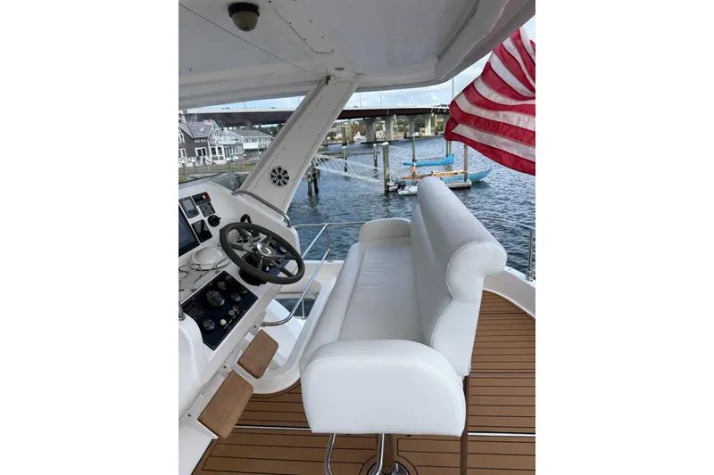 Slide: The Image of Helm of 2012 Leopard 47 PC Owners' Version yacht with American flag and waterfront view. - 19