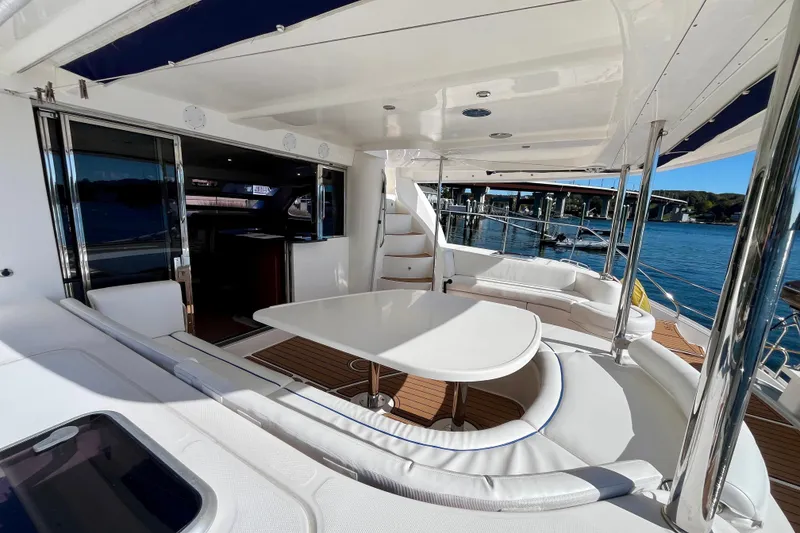 Slide: The Image of Luxurious 2012 Leopard 47 PC yacht deck with seating, table, and scenic water view. - 2