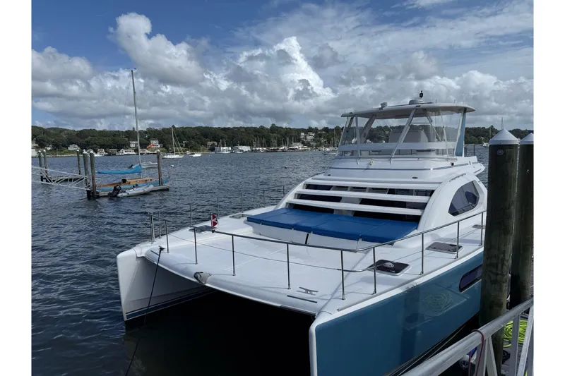 Slide: The Image of 2012 Leopard 47 PC Owners' Version catamaran docked at a marina under cloudy skies. - 35