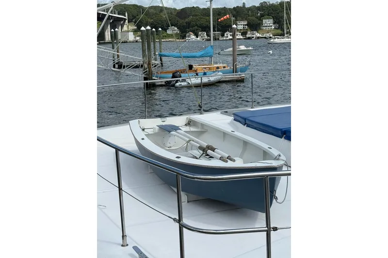 Slide: The Image of 2012 Leopard 47 PC Owners' Version yacht with dinghy on deck, docked in a marina. - 36