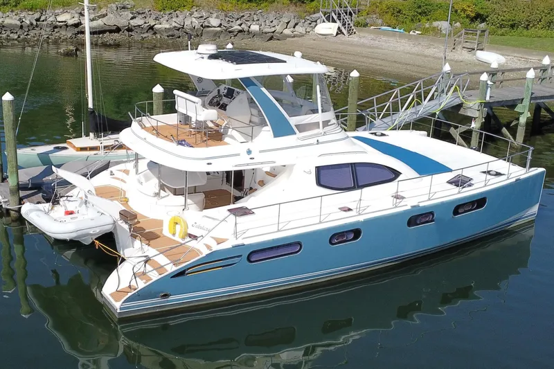Slide: The Image of 2012 Leopard 47 PC Owners' Version catamaran docked in a serene marina setting. - 43