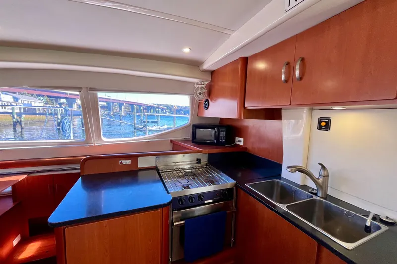 Slide: The Image of Interior of 2012 Leopard 47 PC yacht kitchen with stove, sink, and waterfront view. - 60