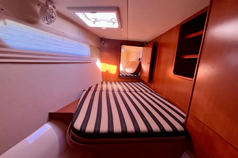 Slide: The Image of Cozy cabin interior of 2012 Leopard 47 PC Owners' Version with striped bedding. - 63