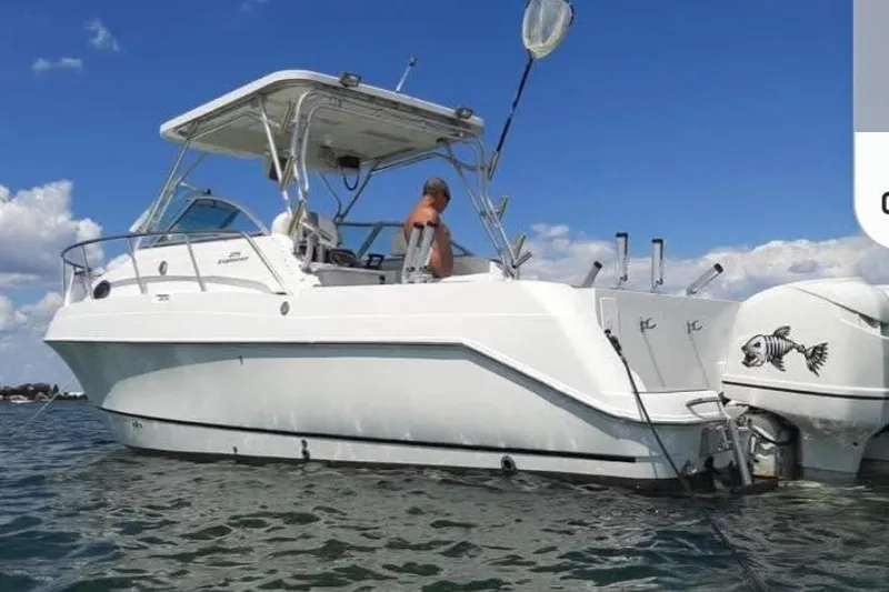 The Image of 2001 Aquasport 28 Walkaround boat on water, clear sky, person onboard. - 1