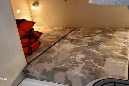 Slide: The Image of 2001 Aquasport 28 Walkaround cabin interior with bed and life jackets. - 10