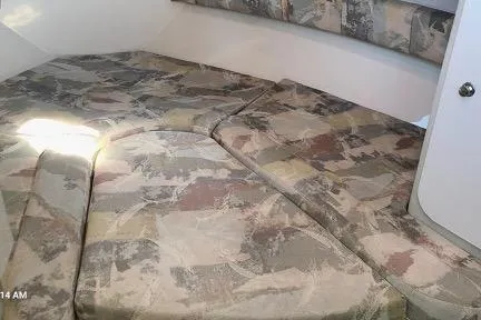 Slide: The Image of 2001 Aquasport 28 Walkaround cabin interior with patterned cushions. - 13