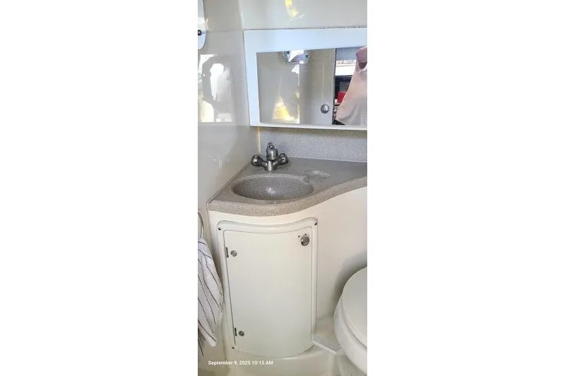 Slide: The Image of 2001 Aquasport 28 Walkaround boat bathroom with sink, mirror, and storage cabinet. - 17