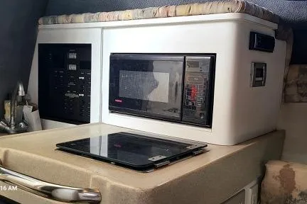Slide: The Image of 2001 Aquasport 28 Walkaround cabin interior with microwave and control panel. - 19