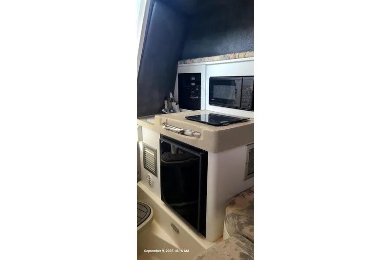 Slide: The Image of 2001 Aquasport 28 Walkaround boat interior with kitchenette, featuring stove and microwave. - 20
