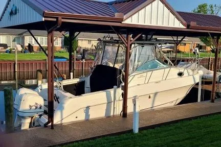 Slide: The Image of 2001 Aquasport 28 Walkaround boat docked under a covered shelter. - 3