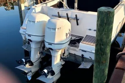 Slide: The Image of 2001 Aquasport 28 Walkaround boat with dual outboard motors docked at marina. - 4
