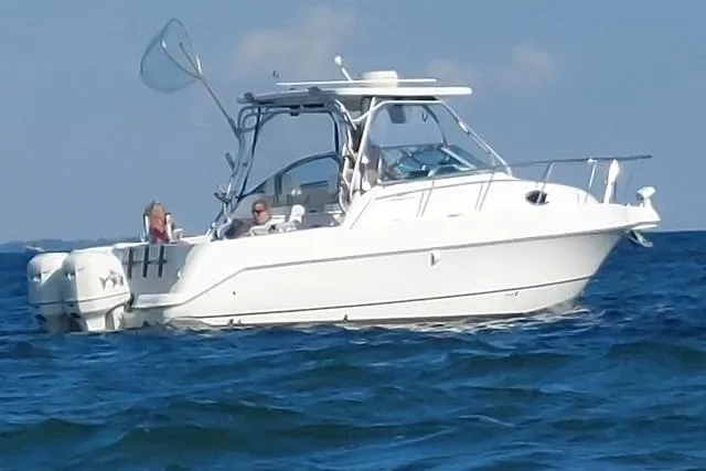 Slide: The Image of 2001 Aquasport 28 Walkaround boat on open water, featuring dual outboard engines. - 6