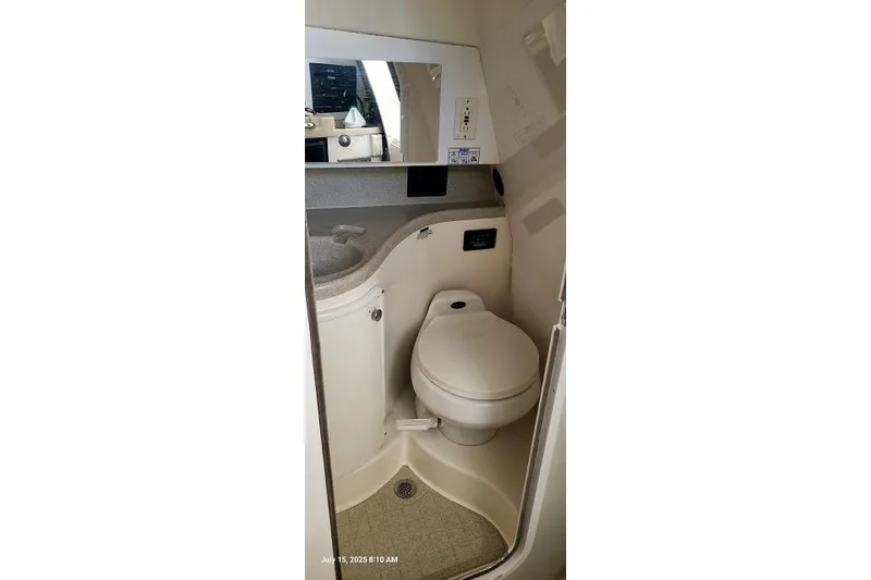 Slide: The Image of 2001 Aquasport 28 Walkaround boat bathroom with toilet, sink, and mirror. - 7