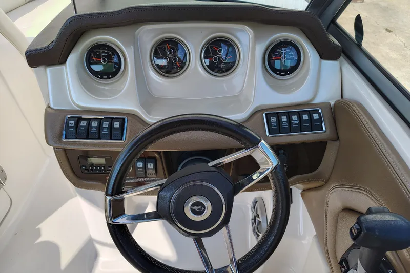 Slide: The Image of 2017 Chaparral 244 Sunesta dashboard with gauges, steering wheel, and control switches. - 19