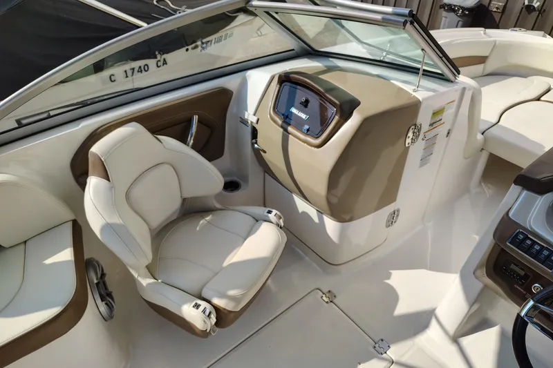 Slide: The Image of 2017 Chaparral 244 Sunesta boat interior with beige seating and control panel. - 20