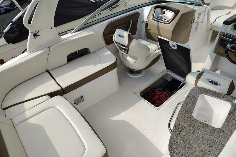 Slide: The Image of 2017 Chaparral 244 Sunesta boat interior with seating, storage, and helm. - 24