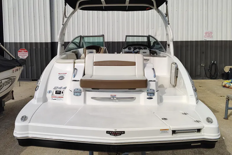 Slide: The Image of 2017 Chaparral 244 Sunesta boat, rear view, white and brown seating, docked outdoors. - 6