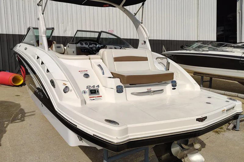 Slide: The Image of 2017 Chaparral 244 Sunesta boat with spacious deck and seating, docked outdoors. - 7