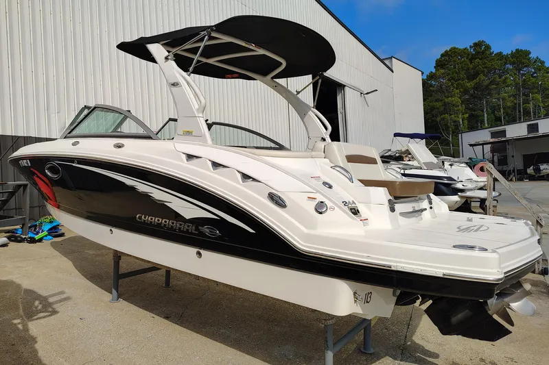 Slide: The Image of 2017 Chaparral 244 Sunesta boat with black and white design, docked outdoors. - 8