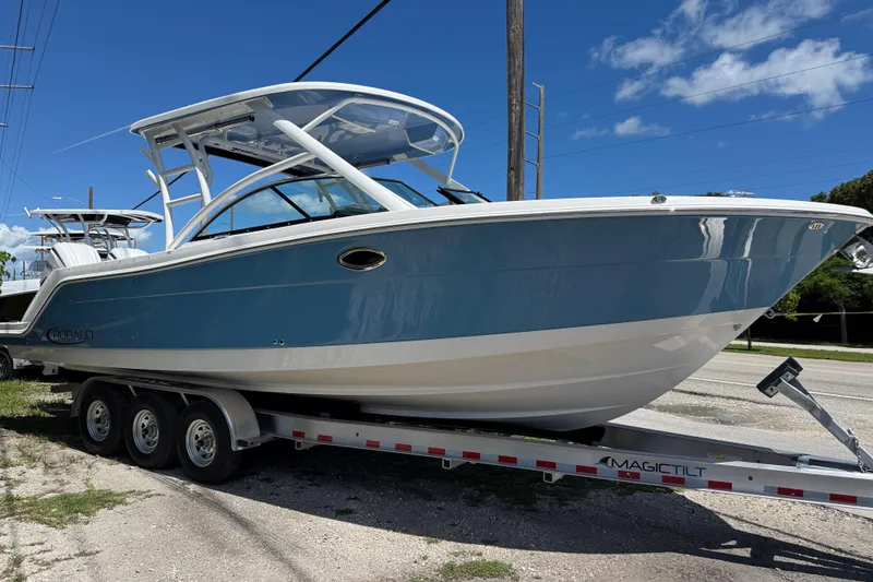 The Image of 2026 Robalo R317 Dual Console boat on trailer under clear blue sky. - 1