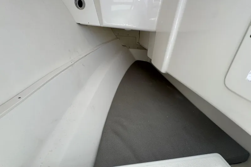 Slide: The Image of Interior view of 2026 Robalo R317 Dual Console boat, featuring sleek white surfaces. - 14