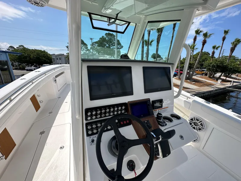 Slide: The Image of 2025 Caymas 34 CT boat cockpit with dual screens and steering wheel. - 4