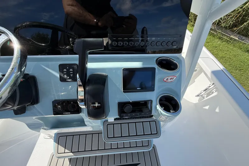 Slide: The Image of 2026 Tidewater 2210 Carolina Bay boat console with controls, display, and cup holders. - 16