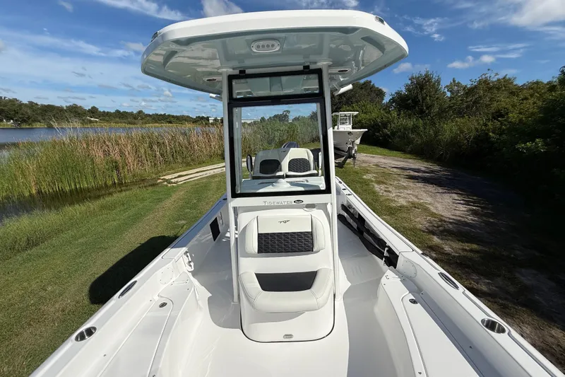 Slide: The Image of 2026 Tidewater 2210 Carolina Bay boat on grassy shore near water and trees. - 20