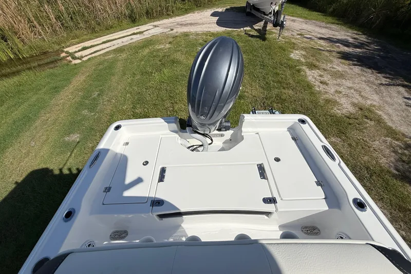 Slide: The Image of 2026 Tidewater 2210 Carolina Bay boat with outboard motor on grassy terrain. - 23